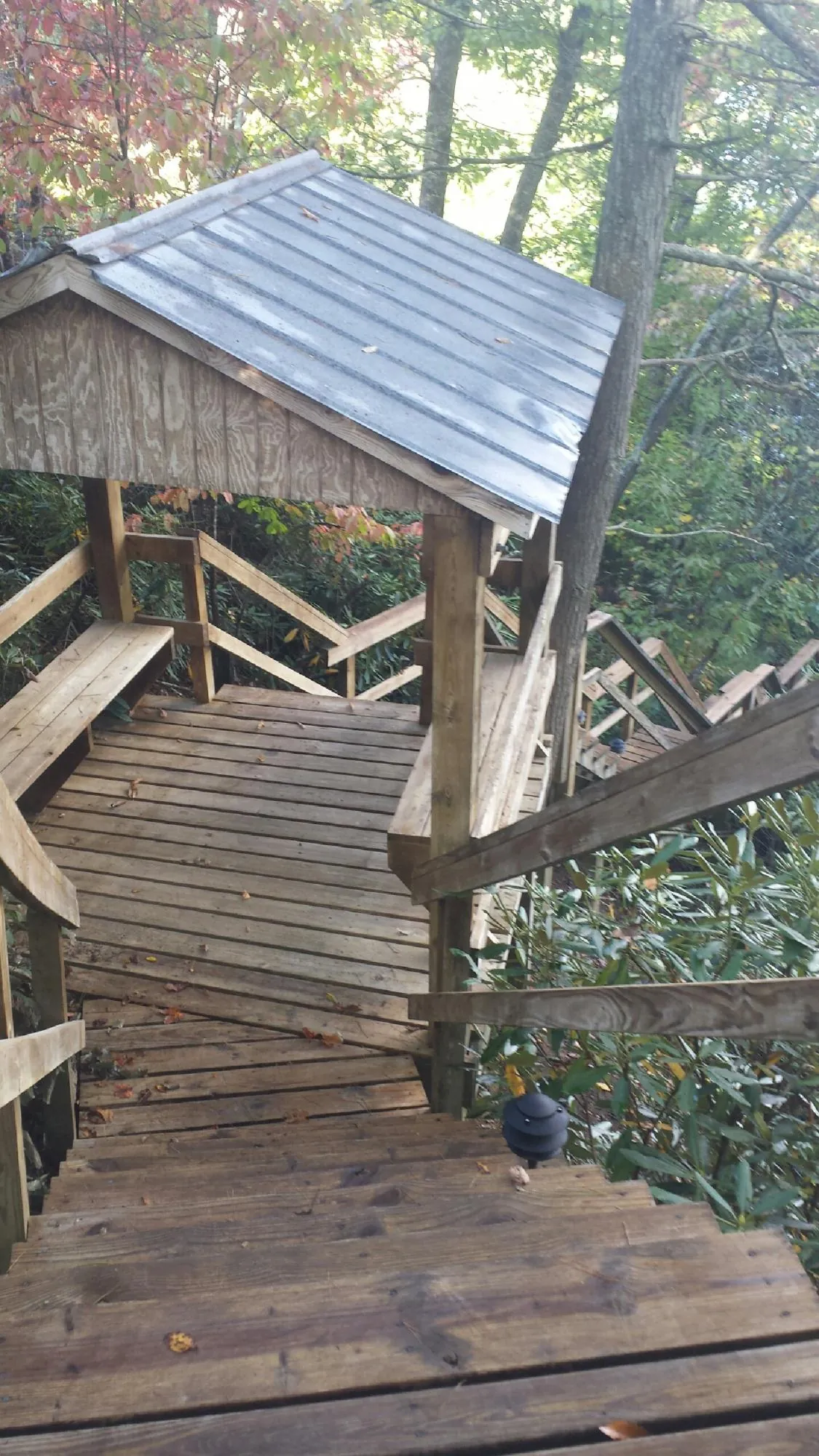 Metal roofed shelter over wooden steps on a wooded walkway — Skylight Repair & Installation work by our crew in Athol